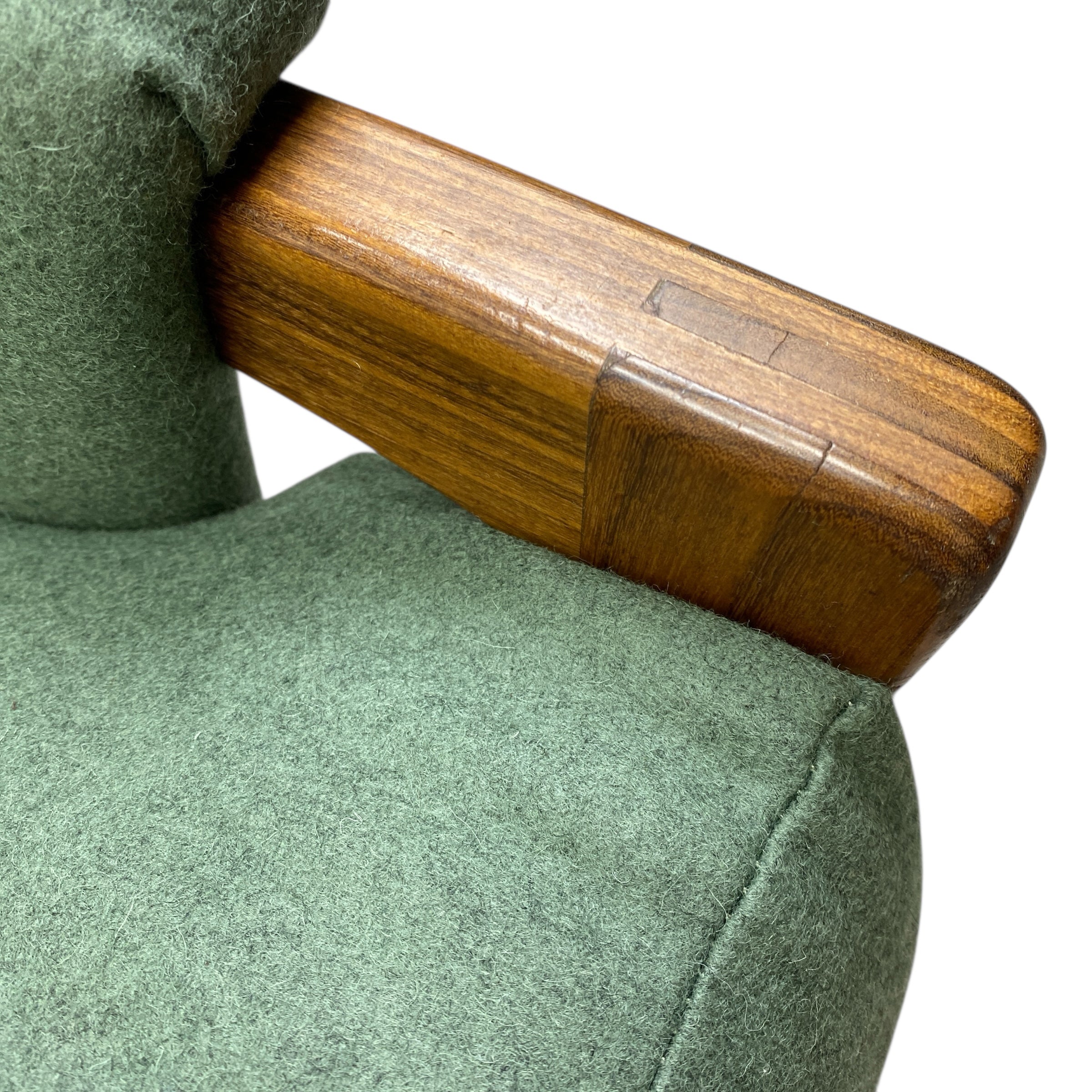 Green upholstered sofa with a wooden armrest on a white background