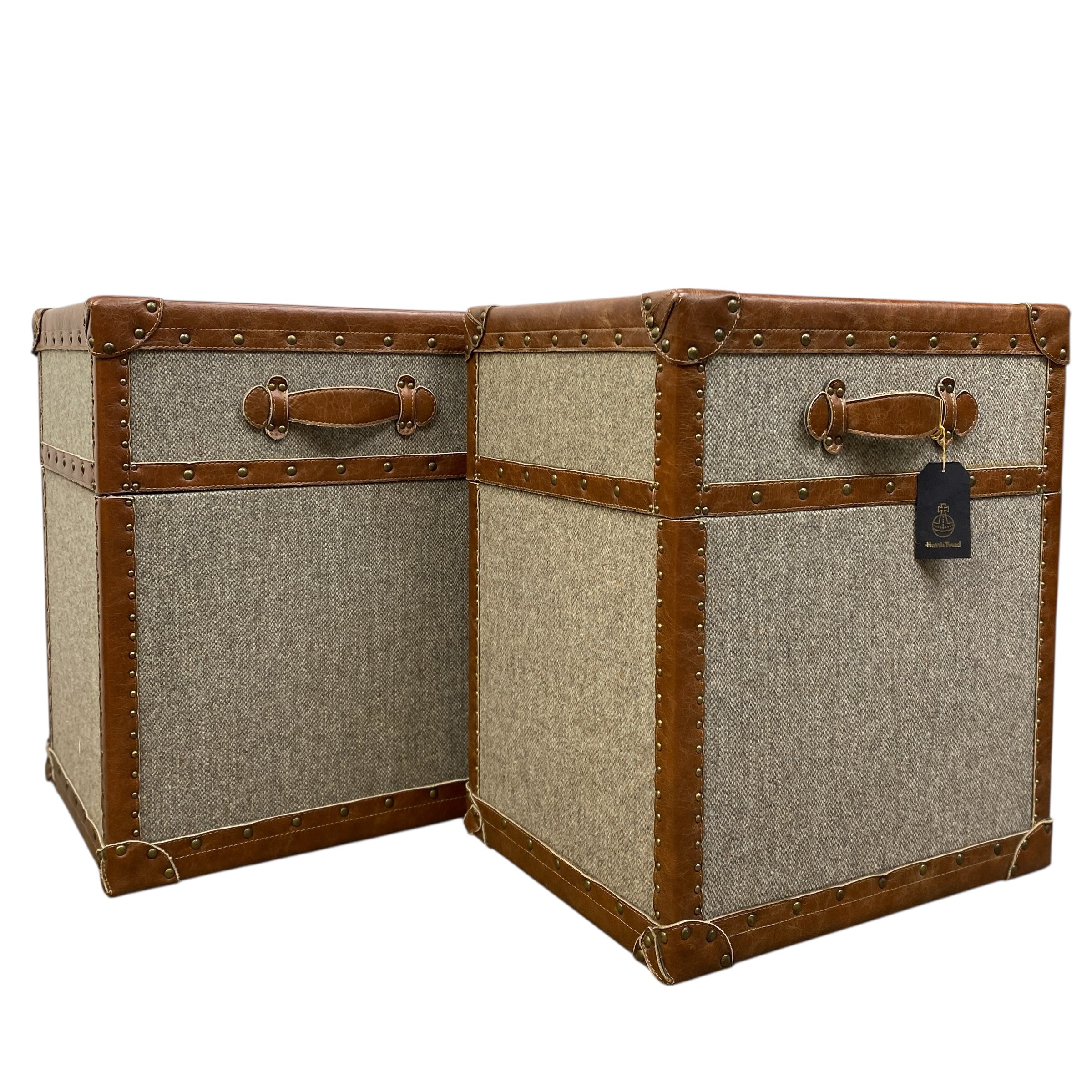Two vintage-style trunks with brown leather accents on a white background