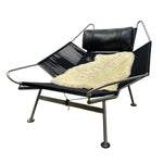 Load image into Gallery viewer, Modern lounge chair with black mesh frame and leather cushion on a white background
