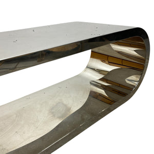 Metallic, curved console table on a white background