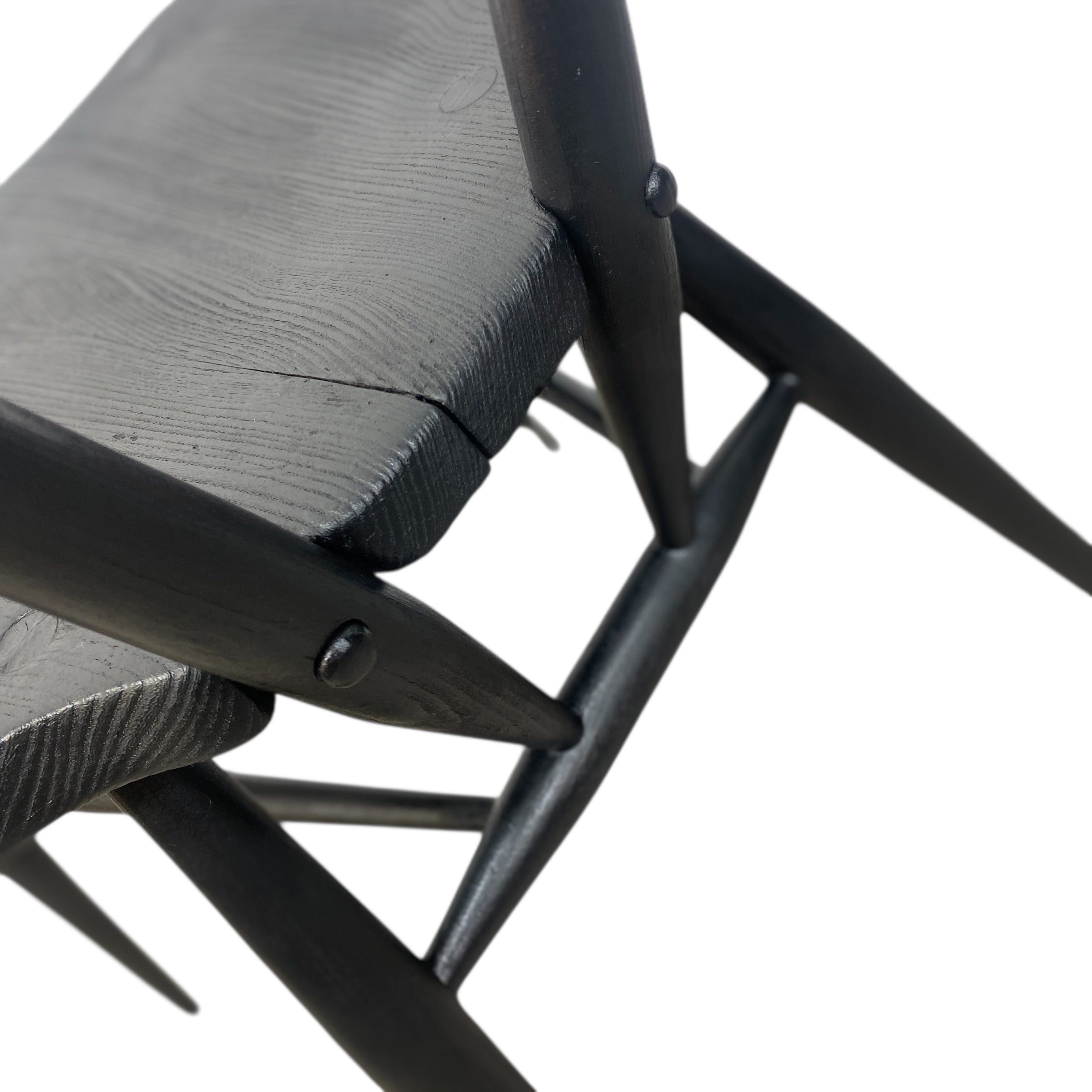 Close-up of a black metal chair with wooden seat on a white background