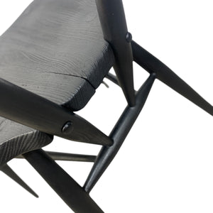 Close-up of a black metal chair with wooden seat on a white background