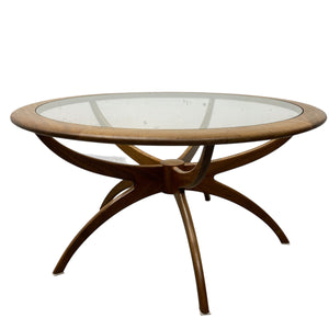 Round wooden table with glass top on a white background