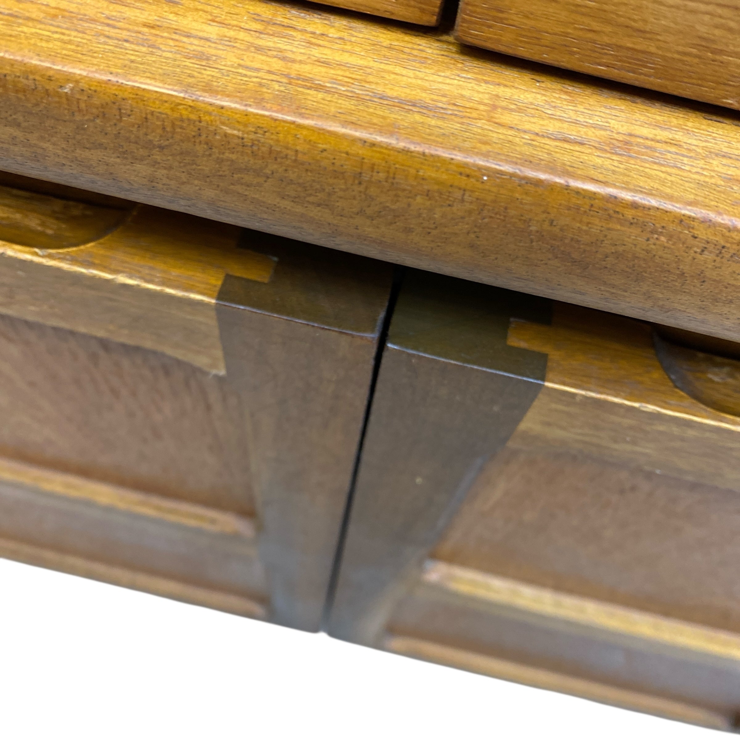 Close-up of a wooden drawer with a metal handle on a white background