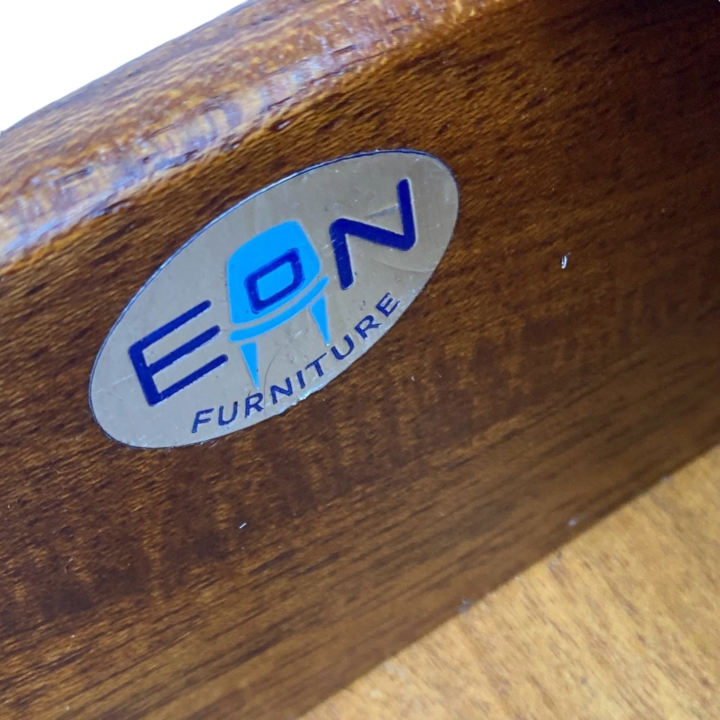 EON Furniture logo on a wooden surface