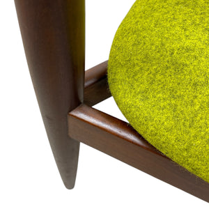 Close-up of a chair with a green cushion and wooden frame on a white background