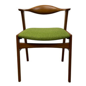 Chair with wooden frame and green cushion on a white background