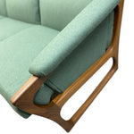 Load image into Gallery viewer, Green upholstered sofa with wooden armrests on a white background
