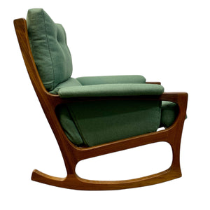 Green upholstered rocking chair with wooden frame on a white background