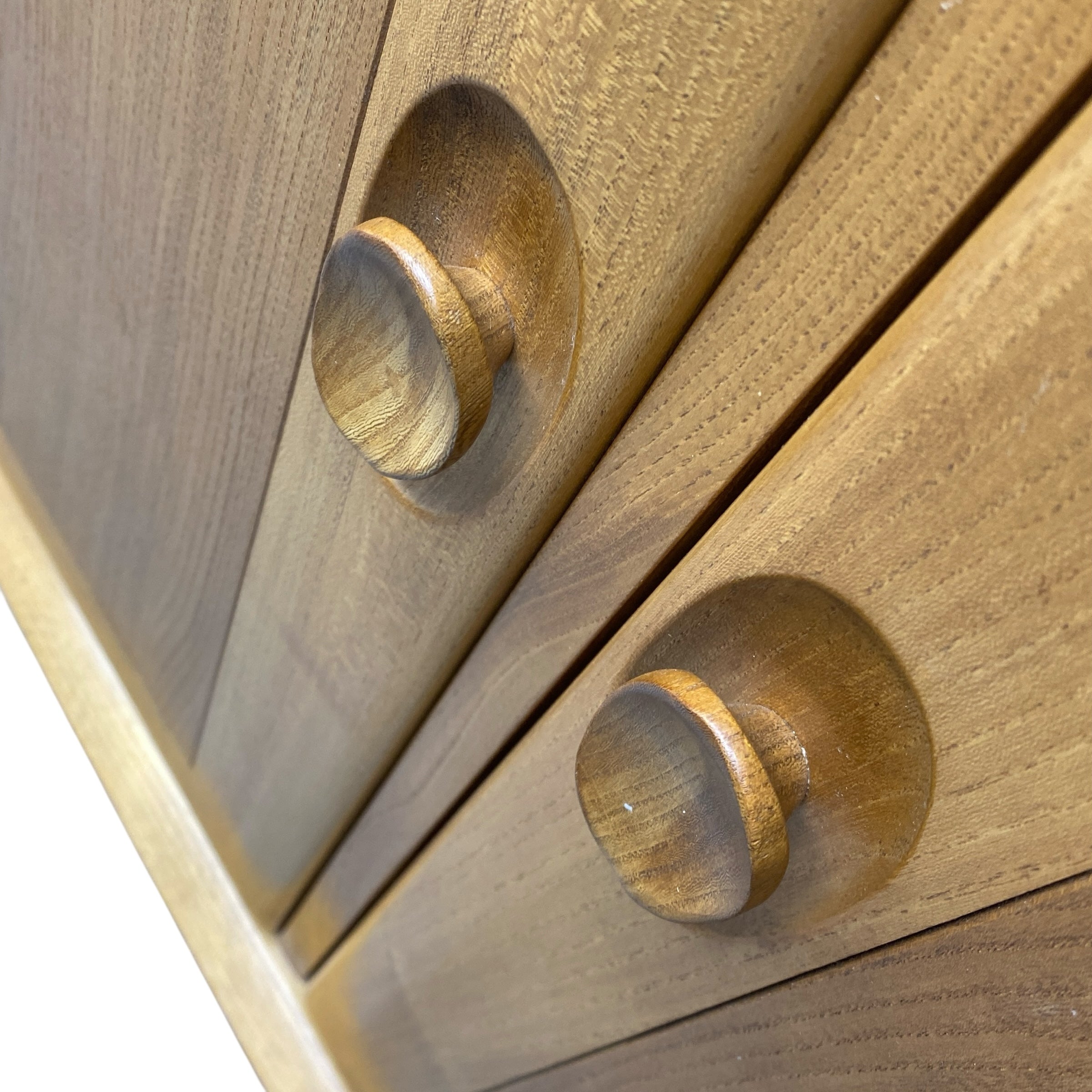 Close-up of wooden drawers with round knobs on a white background