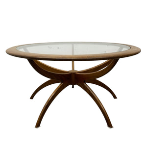 Round wooden table with glass top on a white background