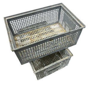 Two gray metal storage baskets stacked on a white background