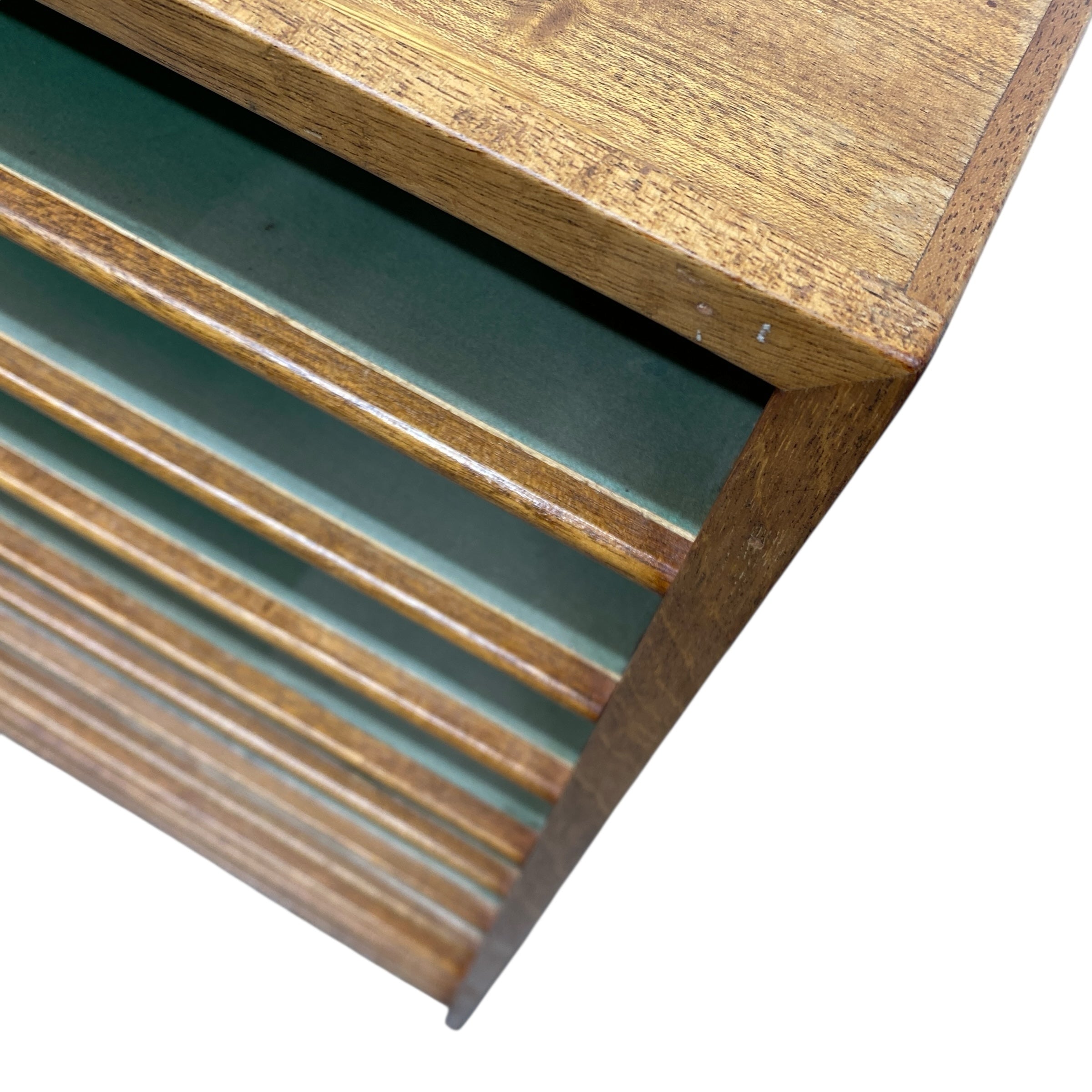 Close-up of a wooden shelf with a green glass panel on a white background