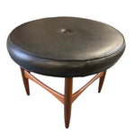 Load image into Gallery viewer, Round black leather ottoman with wooden legs on a white background
