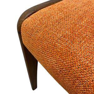 G plan Close-up of an orange textured chair with a wooden armrest on a white background