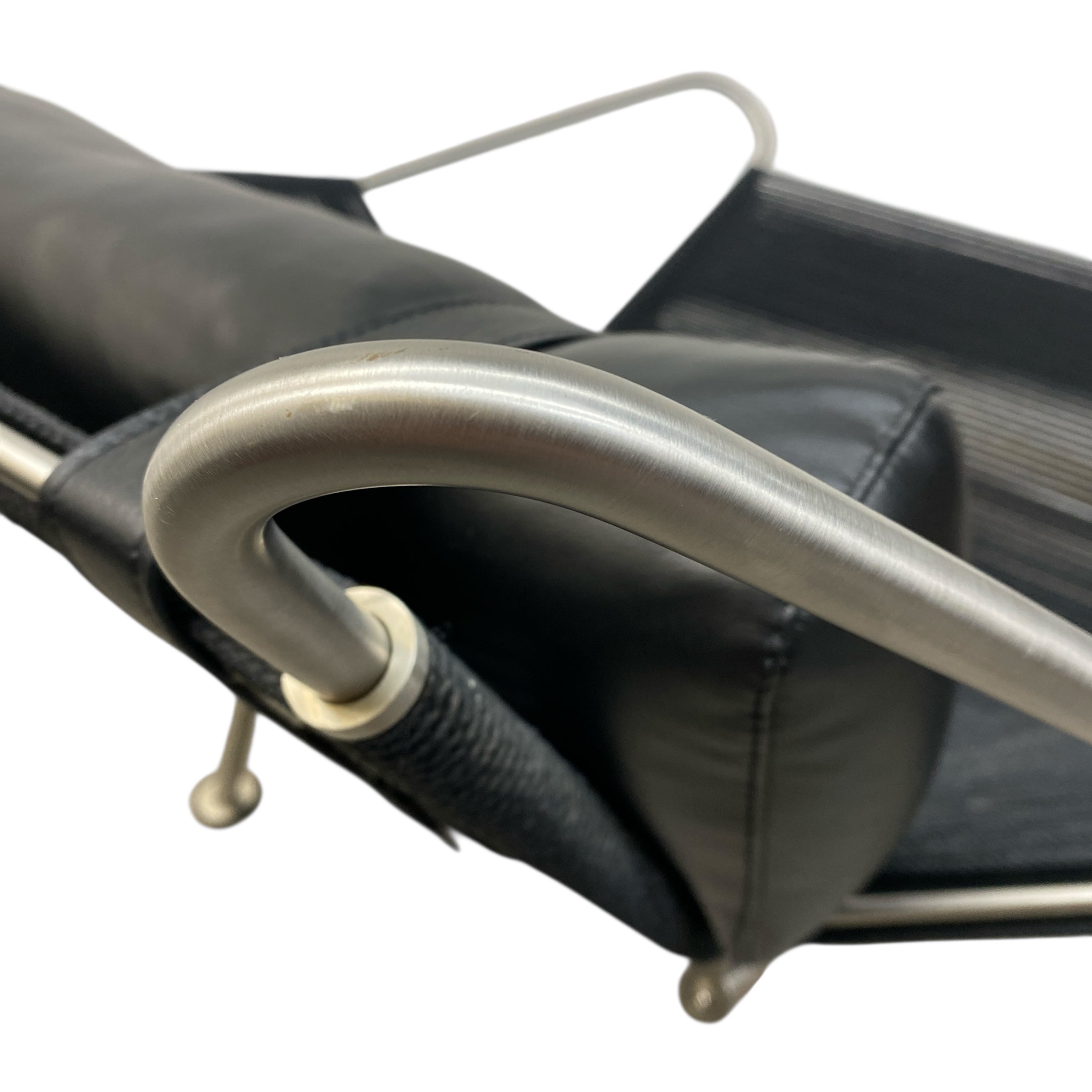 Close-up of a black leather chair with a metal armrest on a white background