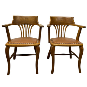 Two wooden chairs with leather seats on a white background