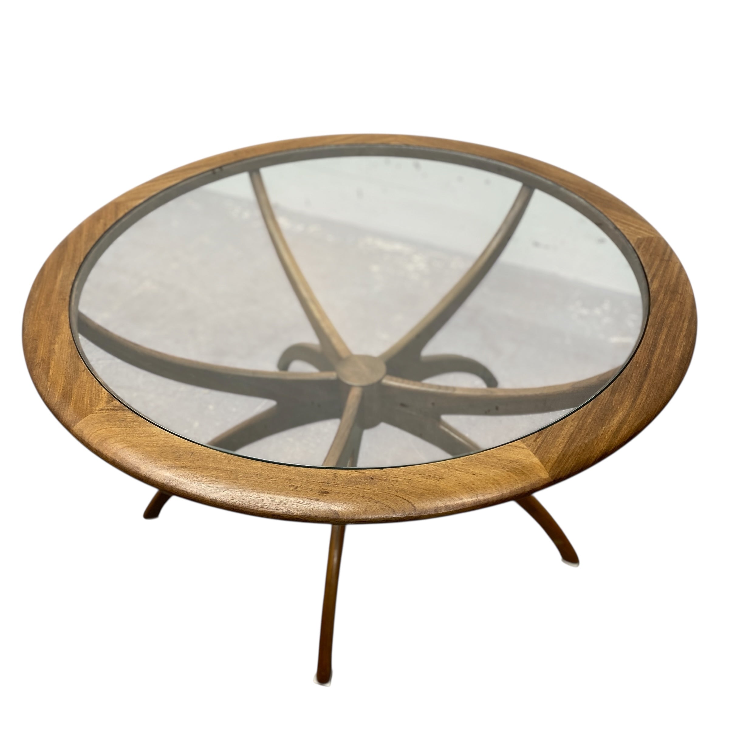 Round wooden coffee table with glass top on a white background