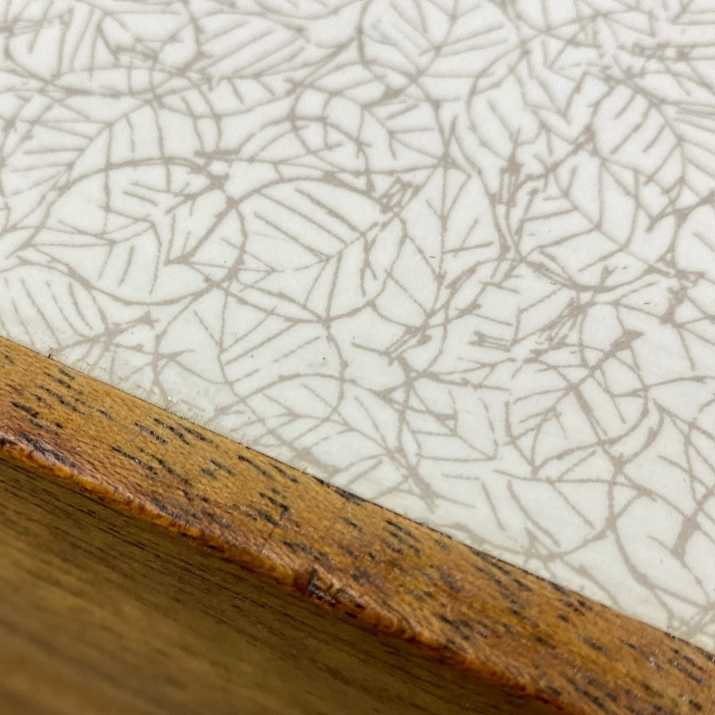 Close-up of a wooden formica surface with a textured white background