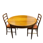 Load image into Gallery viewer, Round wooden dining table with four chairs on a white background
