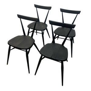 Four black wooden chairs on a white background