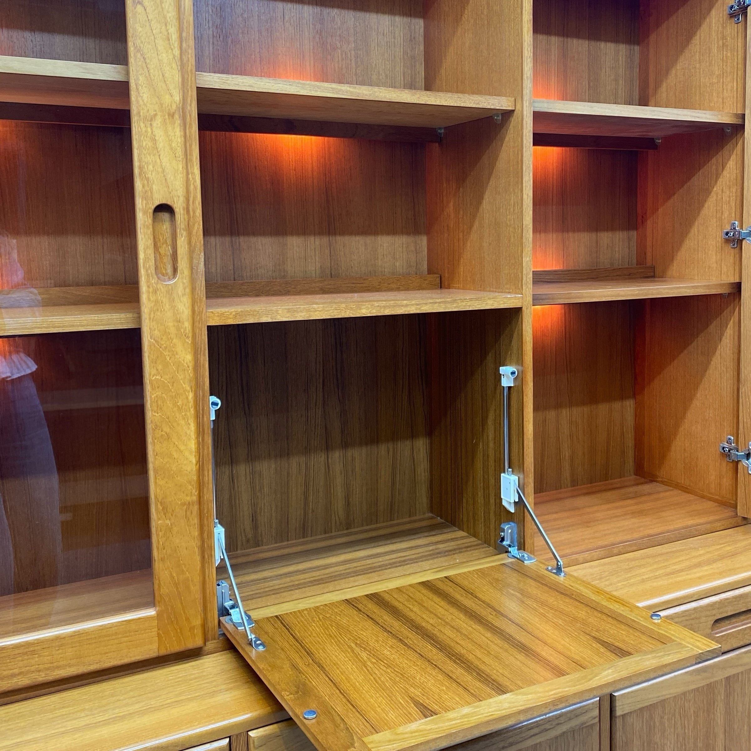 Wooden cabinet with open doors showing shelves and a partially open door.