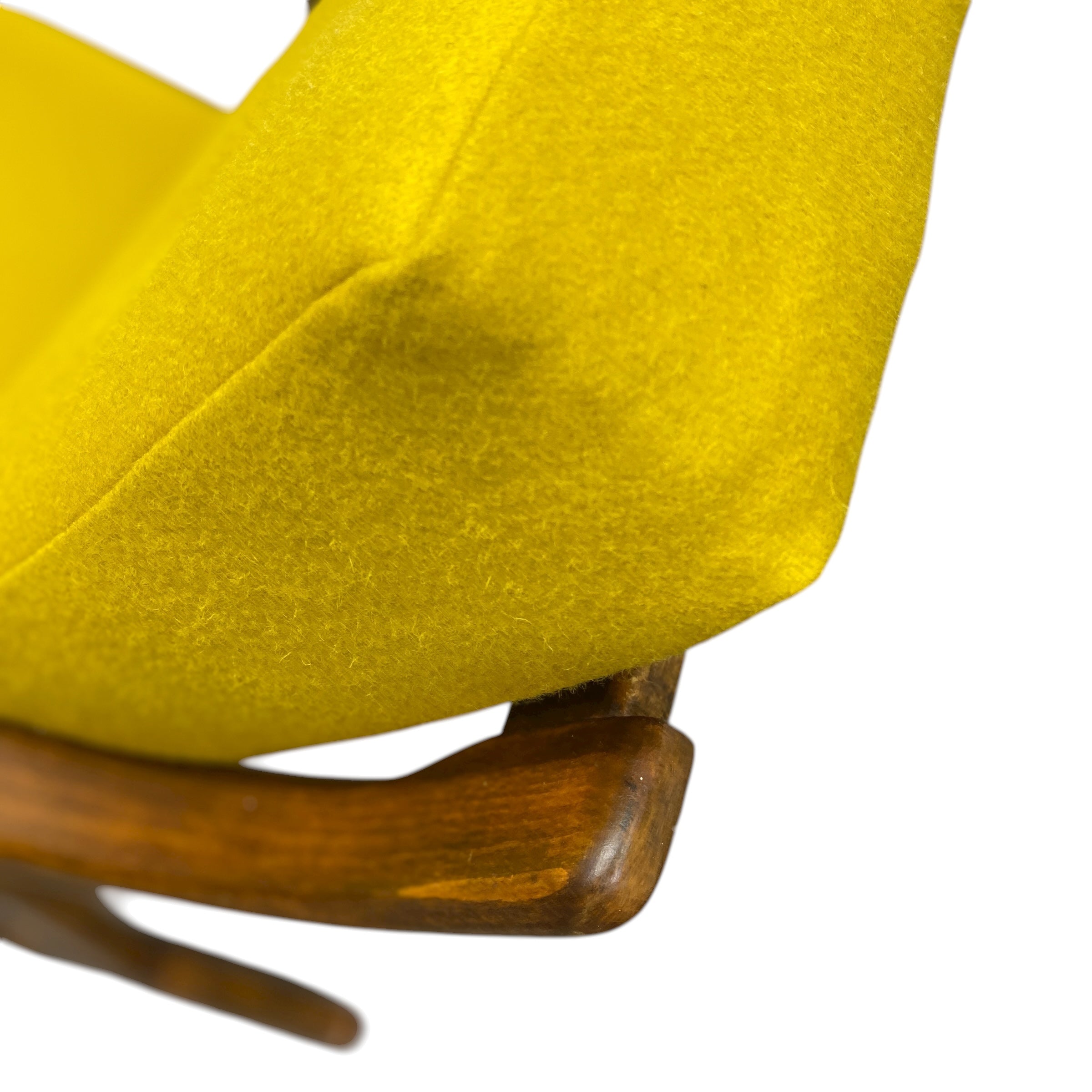 Close-up of a yellow chair with wooden legs on a white background