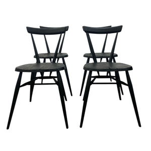 Four black wooden chairs on a white background