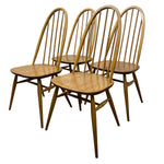 Load image into Gallery viewer, Four wooden chairs with spindle backs on a white background
