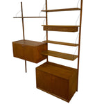 Load image into Gallery viewer, Wooden wall unit with shelves and cabinets on a white background
