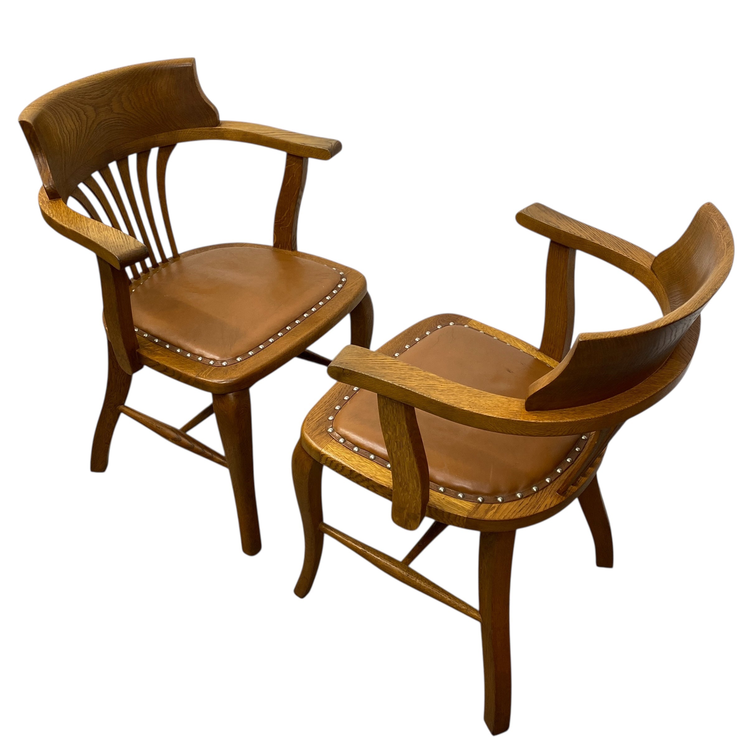 Two wooden chairs with leather seats on a white background