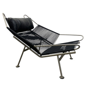 Modern lounge chair with black leather and metal frame on a white background