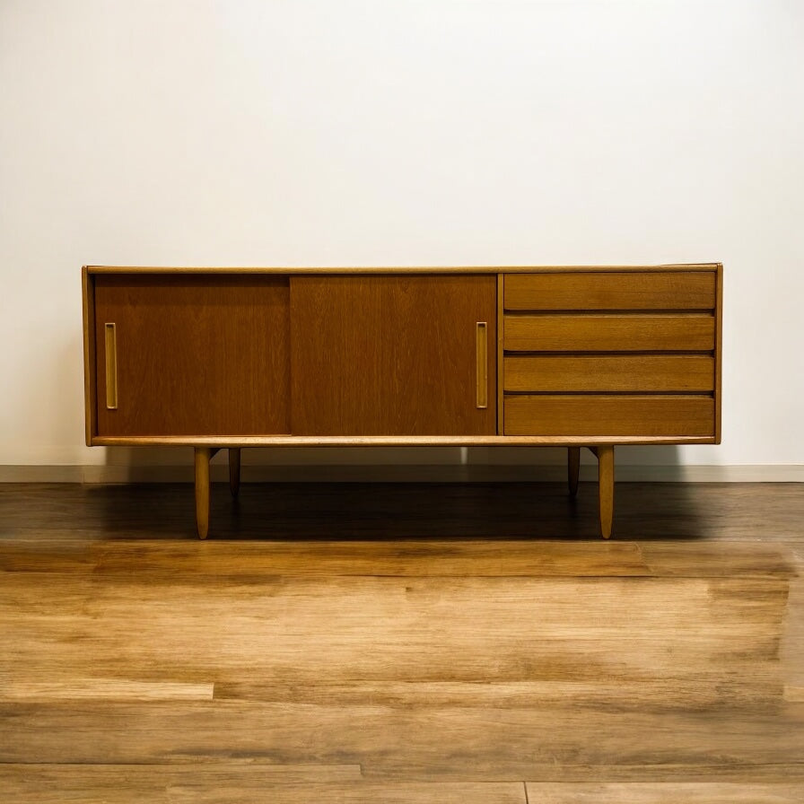 Wooden sideboard with drawers on a wooden floor against a white wall