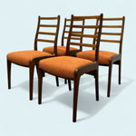 Load image into Gallery viewer, Four wooden chairs with orange seats on a light blue background
