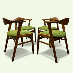 Danish Four wooden chairs with green cushions on a white background