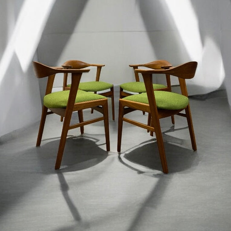 Wooden chairs with green cushions arranged in a circle on a gray floor.
