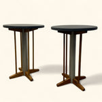 Load image into Gallery viewer, Two round tables with dark tops and wooden bases on a white background
