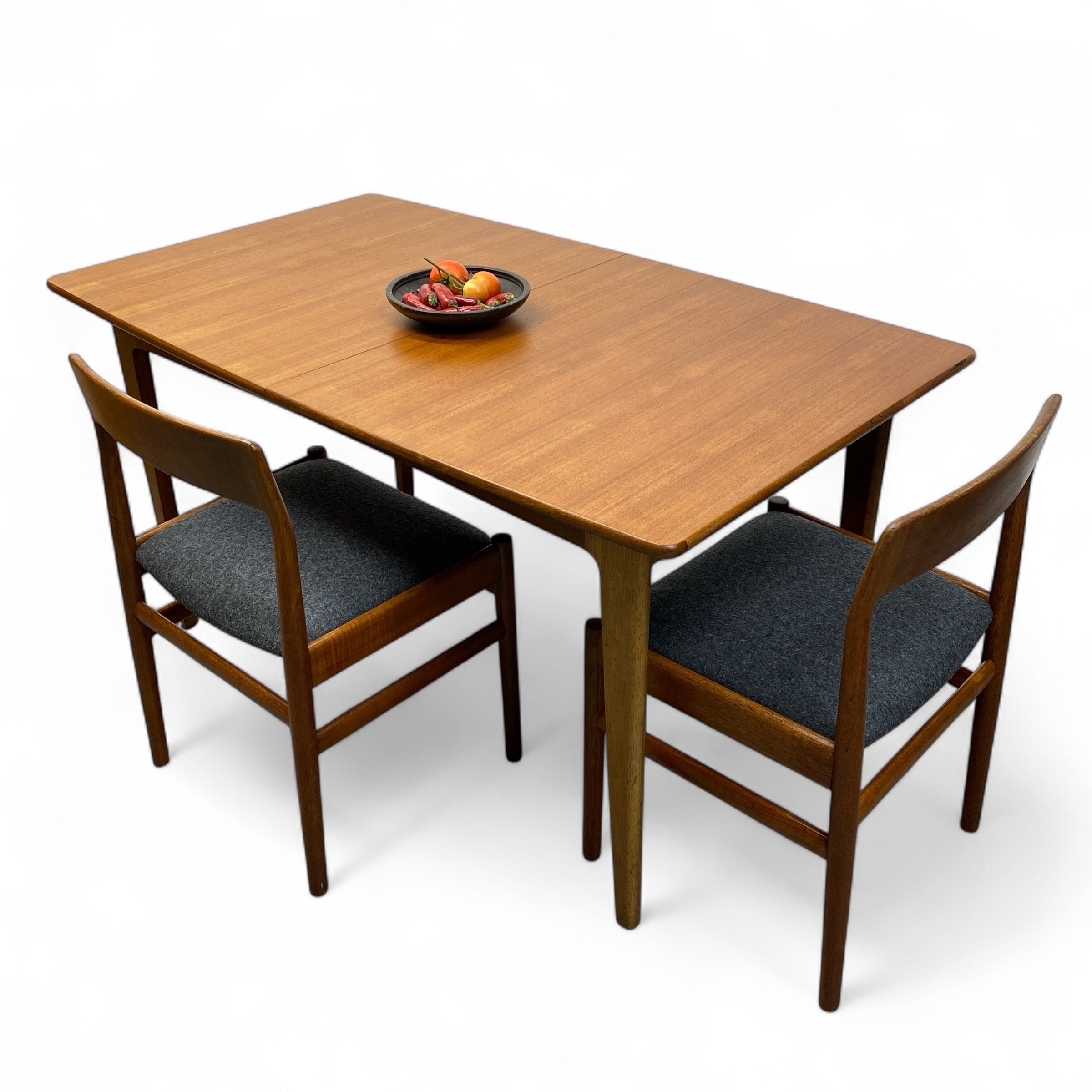 Wooden dining table with two chairs on a white background