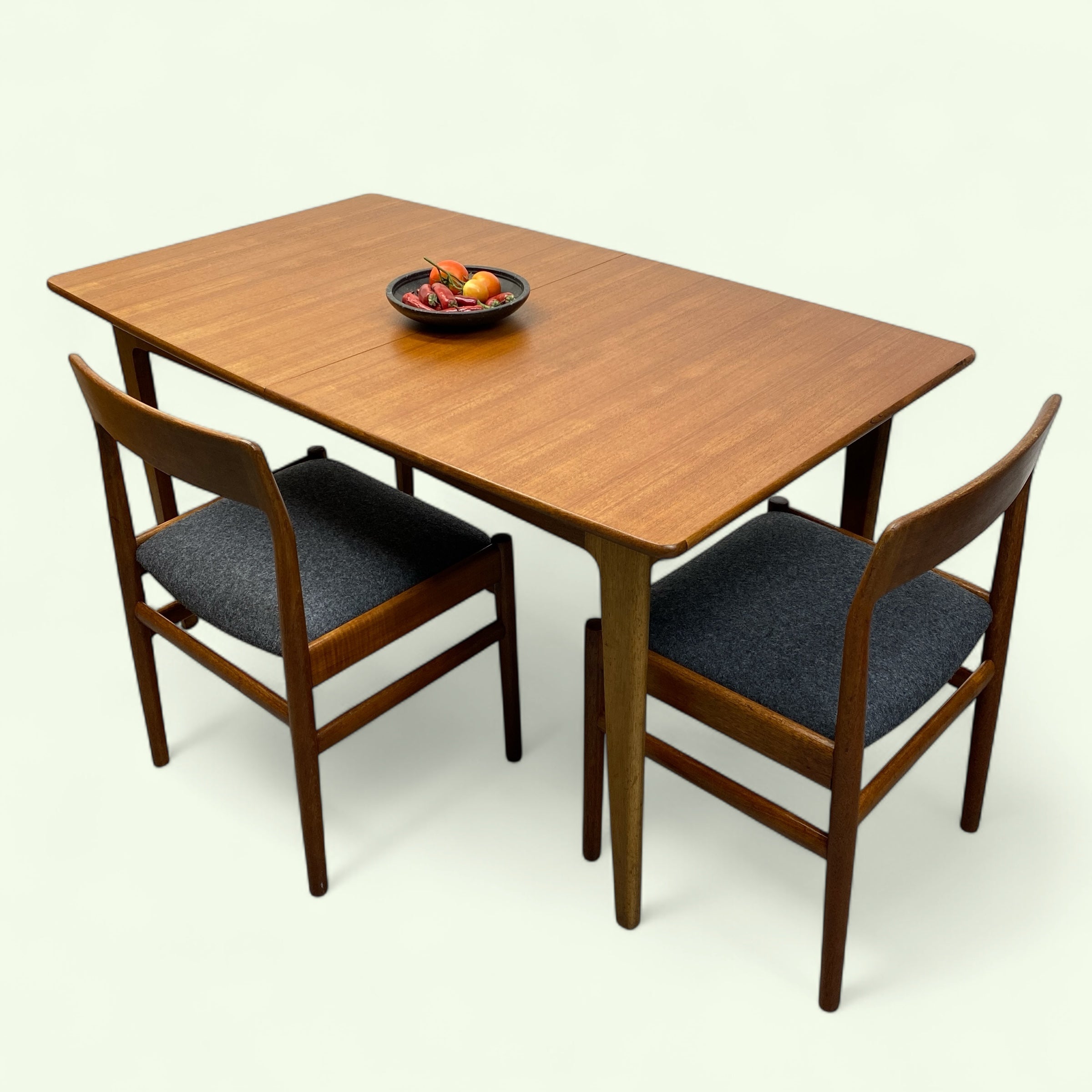 Wooden dining table with two chairs on a white background