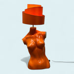 Load image into Gallery viewer, Orange lamp shaped like a torso on a light blue background
