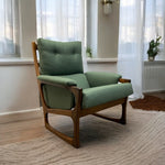 Load image into Gallery viewer, Green armchair in a room with large windows and curtains
