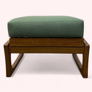 Wooden ottoman with a green cushion on a white background