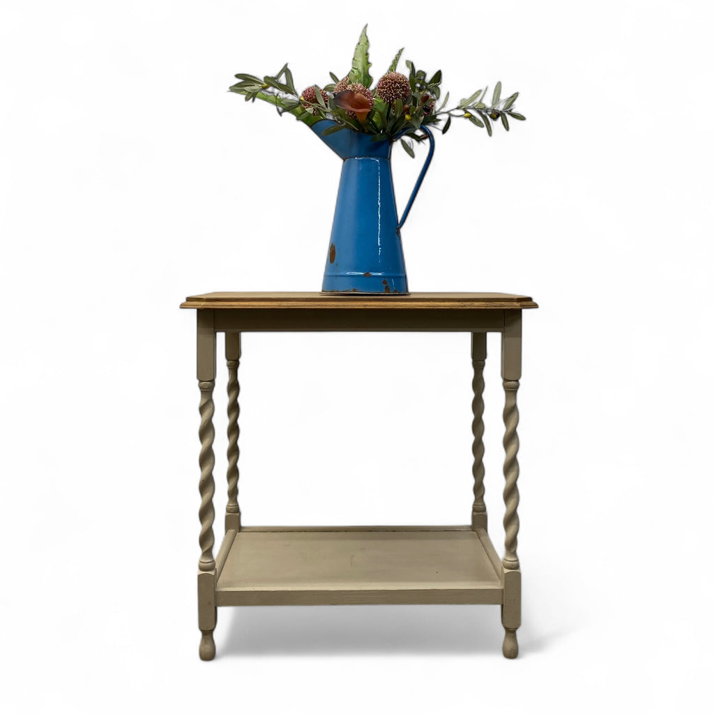 Wooden side table with a blue vase and floral arrangement on a white background