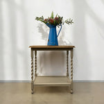 Load image into Gallery viewer, Wooden side table with a blue pitcher and floral arrangement against a white wall.

