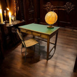 Load image into Gallery viewer, Vintage desk with a chair and a glowing globe in a dimly lit room.
