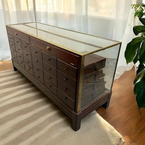 Wooden display case with glass top on a striped rug