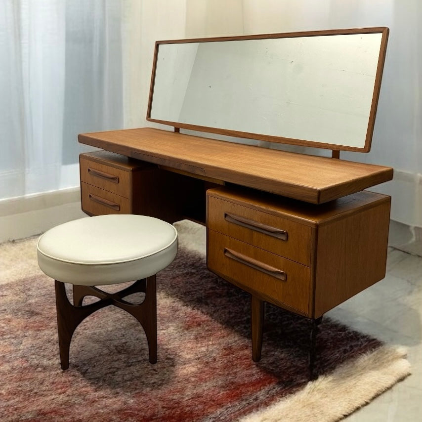 Wooden vanity desk with mirror and stool on a patterned rug
