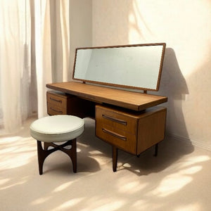 Wooden vanity table with mirror and stool in a softly lit room