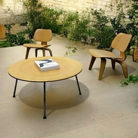 Round wooden table with a book on it, surrounded by chairs in an outdoor setting.