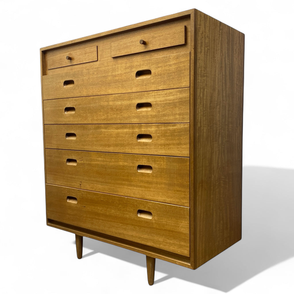 Wooden tall boy with multiple drawers on a white background